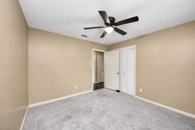 a view of a big room with a ceiling fan and a window