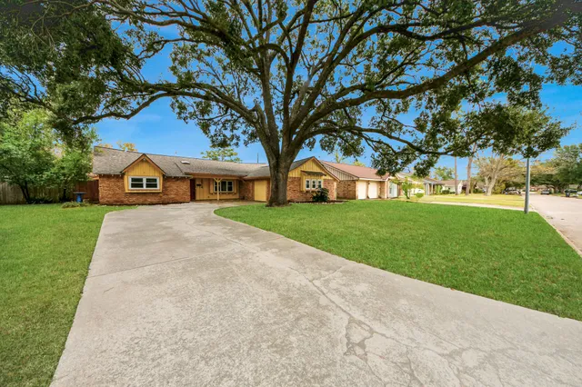 a view of house with garden and tall trees