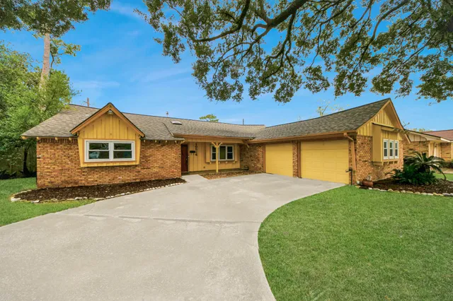 a front view of a house with a garden and yard