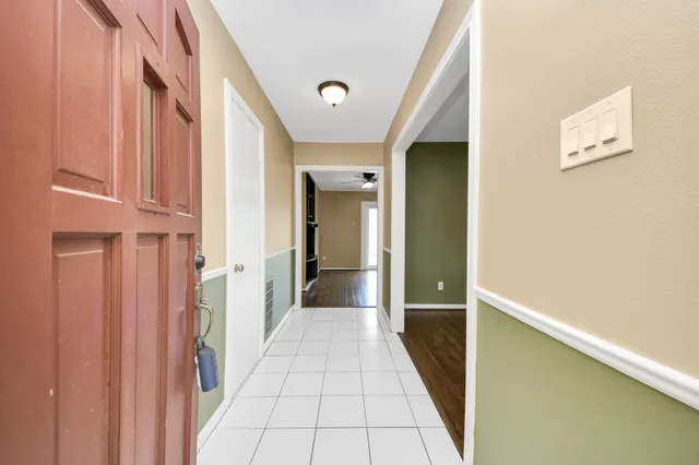 a view of a hallway with wooden floor and staircase