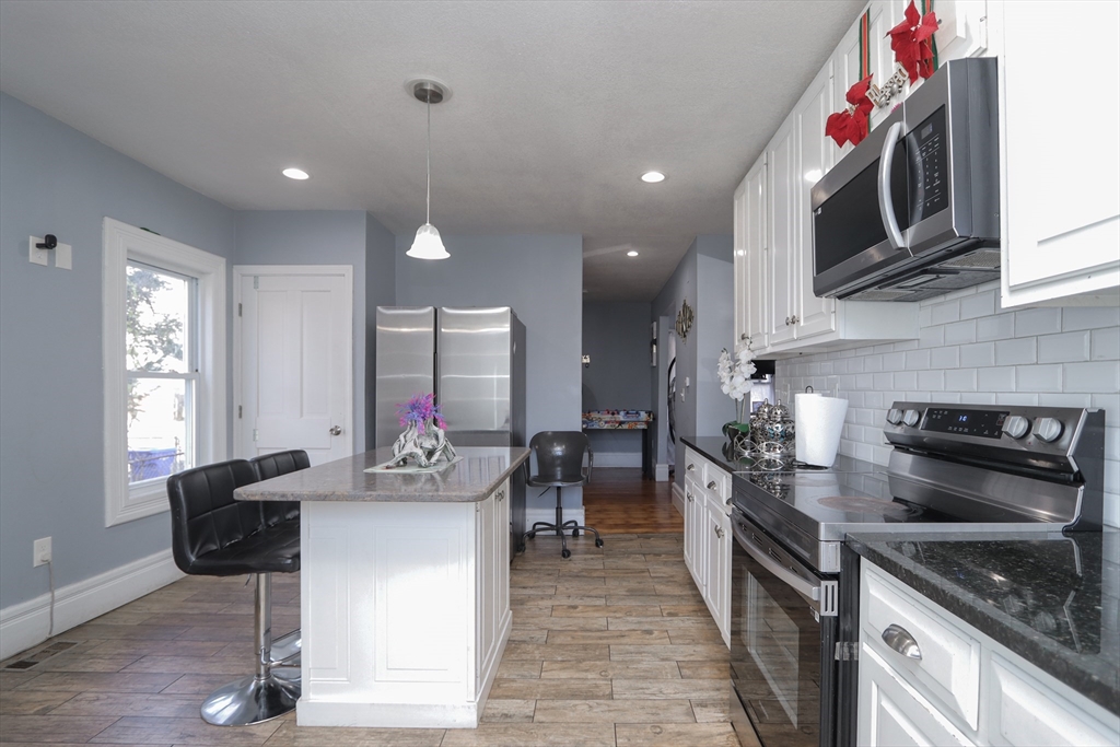58 Willard Avenue Springfield, MA 01109 - Photo 13 of 32 a kitchen with stainless steel appliances granite countertop a stove top oven a sink dishwasher and cabinets with wooden floor