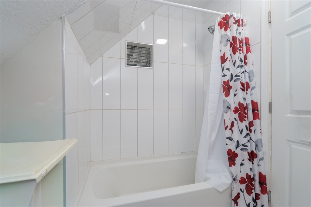 58 Willard Avenue Springfield, MA 01109 - Photo 31 of 32 a bathroom with a bathtub and a shower curtain