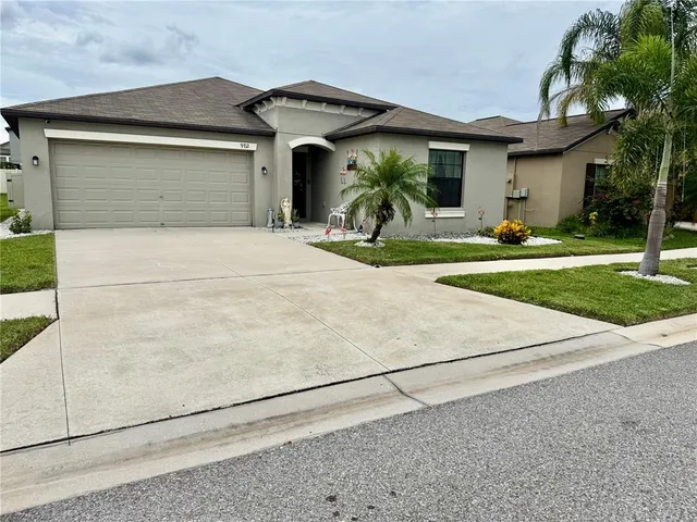 a front view of a house with a yard and garage