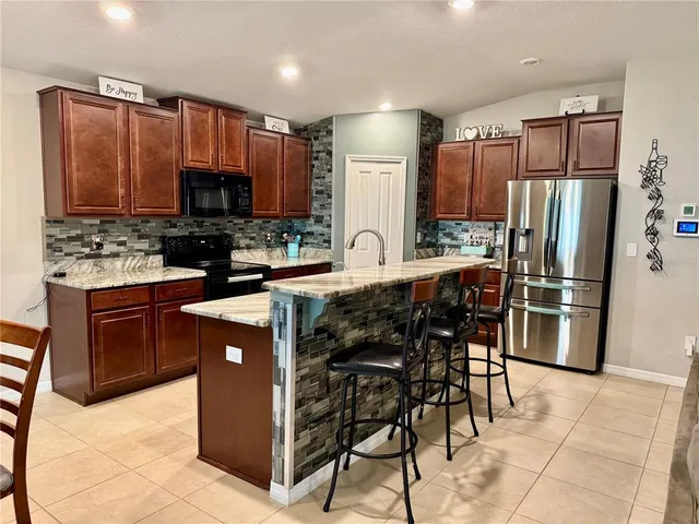 a kitchen with stainless steel appliances a stove a sink a refrigerator and a refrigerator