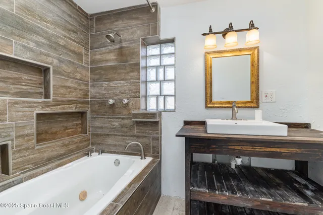 a bathroom with a tub a sink and a mirror
