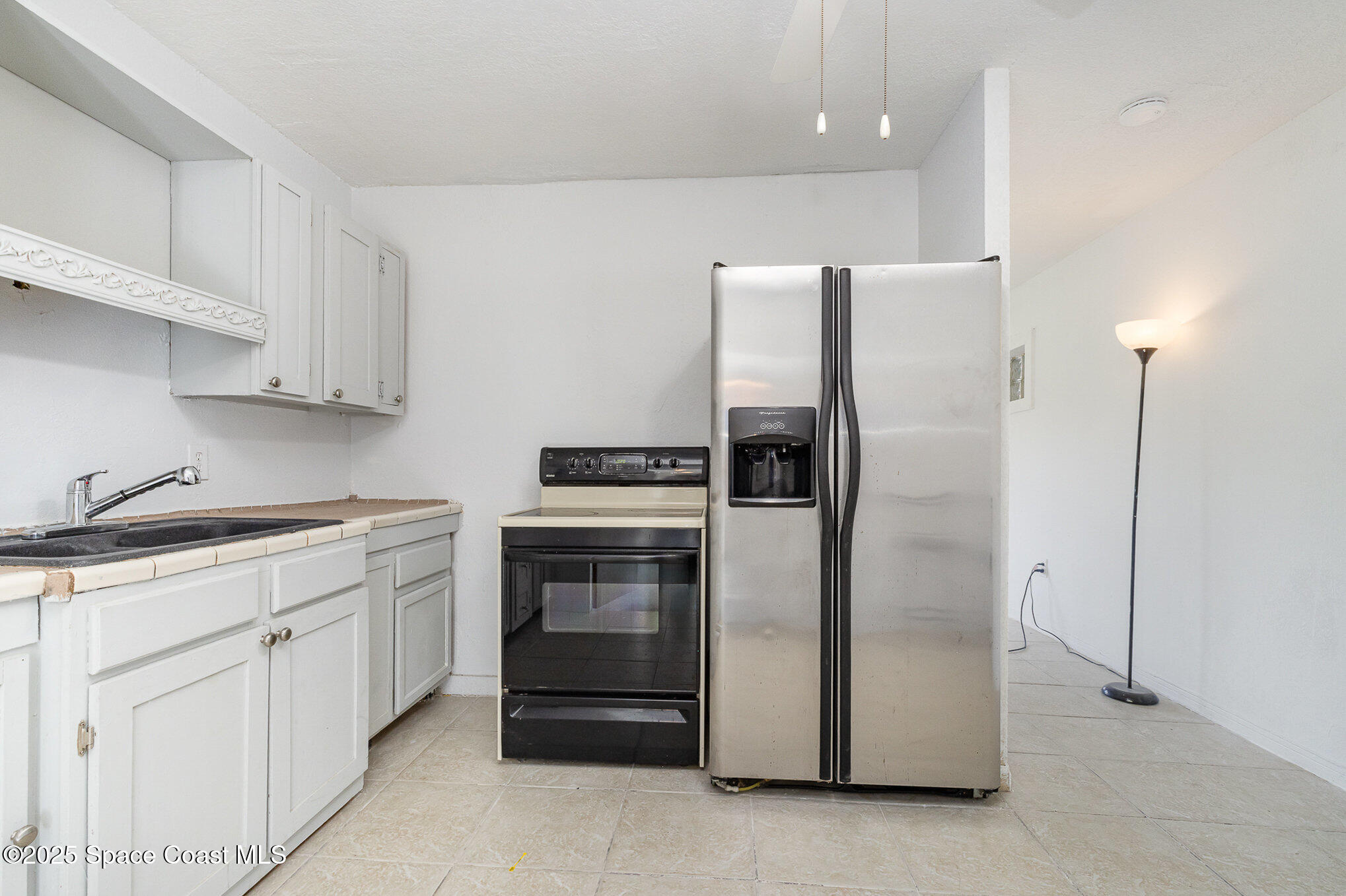 2234 Post Road Melbourne, FL 32935 - Photo 15 of 29 a kitchen with a refrigerator sink and cabinets