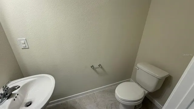 a white toilet sitting next to a white sink and vanity
