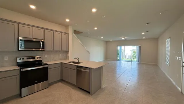 a kitchen with stainless steel appliances granite countertop a sink and a microwave