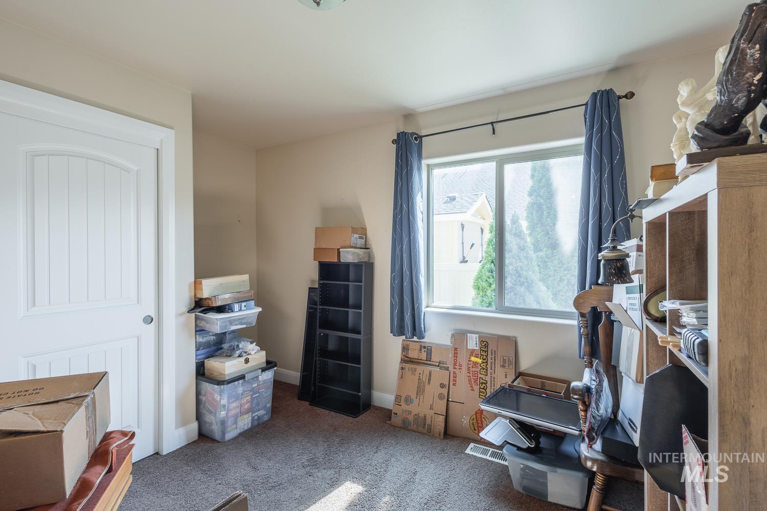 1186 East Observation Street Meridian, ID 83642 - Photo 27 of 33 Carpeted room with a double-pane window, white trim, light-colored walls, and a white interior door with vertical paneling