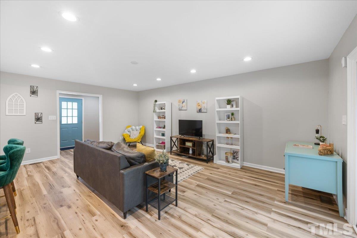 3101 Crandon Lane Raleigh, NC 27604 - Photo 6 of 18 a living room with furniture a flat screen tv and a fireplace
