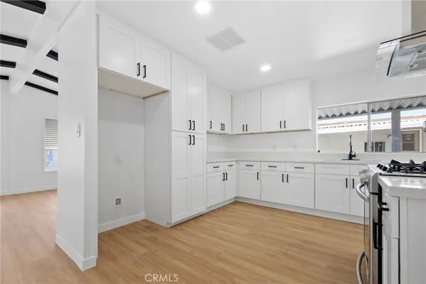 a kitchen with stainless steel appliances granite countertop a sink stove and cabinets