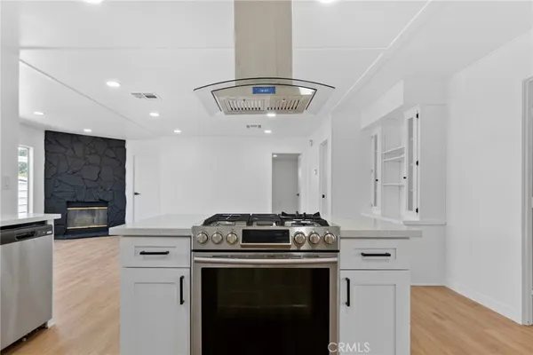 a kitchen with stainless steel appliances a sink cabinets and wooden floor