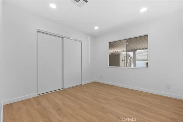 a view of a room with wooden floor and a ceiling fan