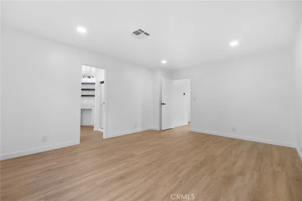 a kitchen with white cabinets and window
