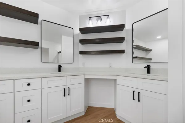 a kitchen with white cabinets and sink