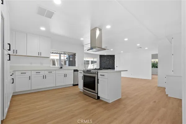 a kitchen with granite countertop white cabinets and stainless steel appliances