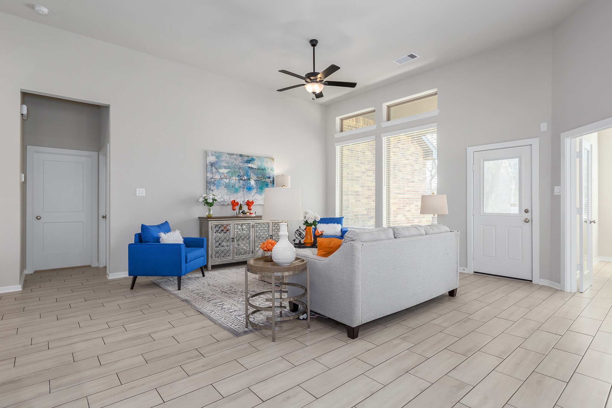 107 Yellow Perch Way Conroe, TX 77318 - Photo 12 of 44 Spacious living area featuring vaulted ceilings, tile flooring, recessed lighting, and large windows that fill the space with natural light and provide views of the backyard.