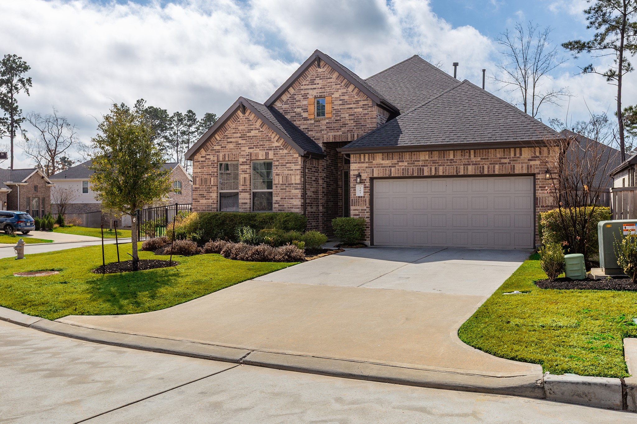 107 Yellow Perch Way Conroe, TX 77318 - Photo 2 of 44 Front elevation in daylight showcasing the brick façade and inviting entry.