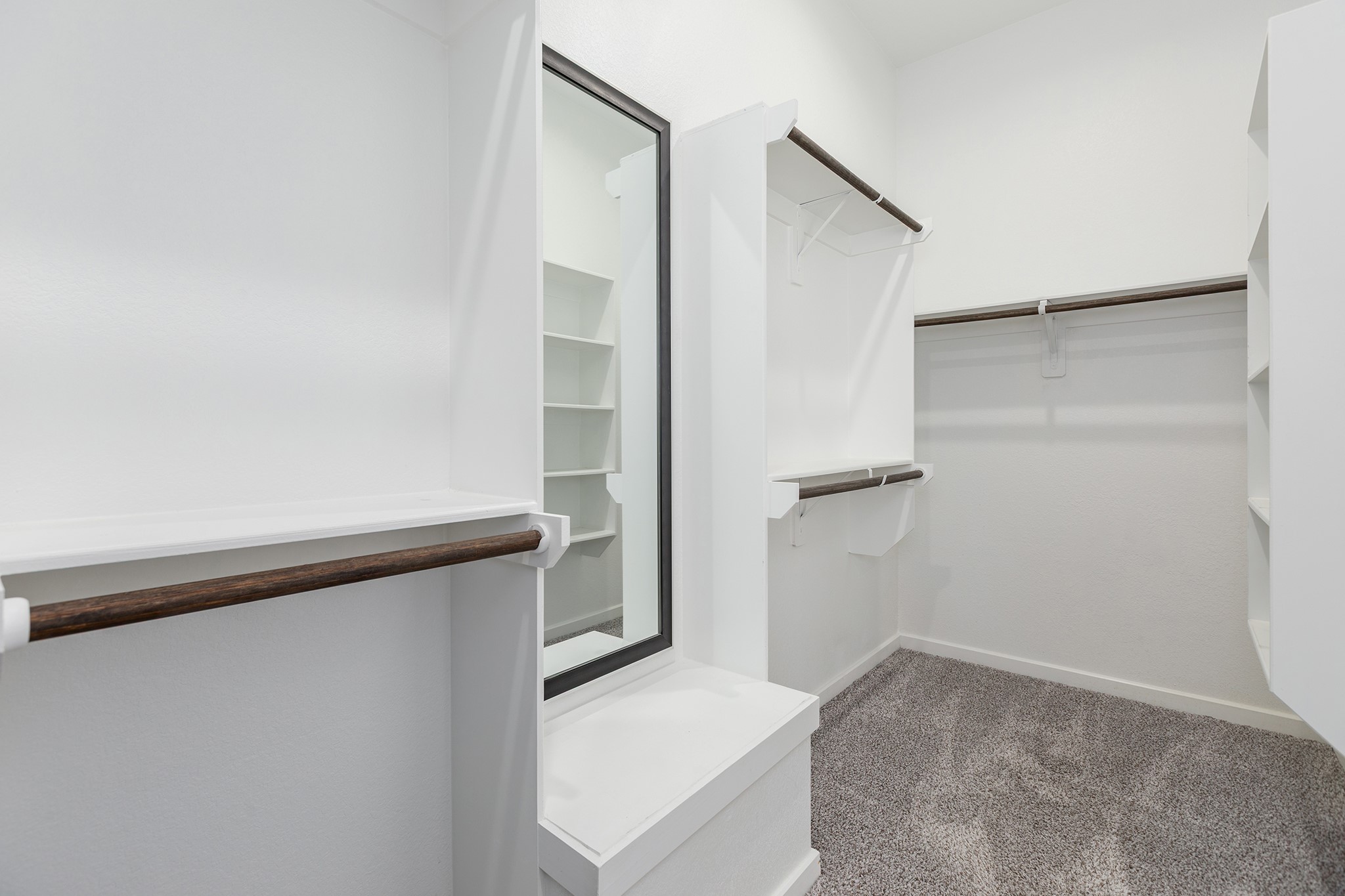 107 Yellow Perch Way Conroe, TX 77318 - Photo 24 of 44 Spacious primary walk-in closet featuring built-in shelving, hanging rods, carpeted flooring, and a convenient built-in bench.