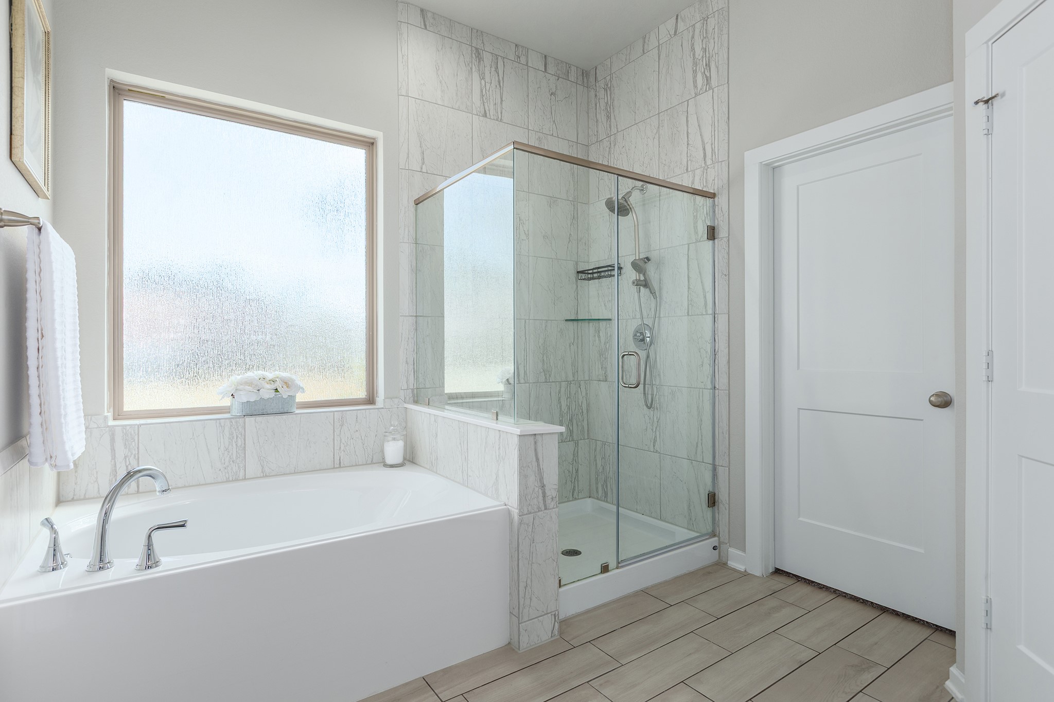 107 Yellow Perch Way Conroe, TX 77318 - Photo 25 of 44 This inviting primary bathroom offers a relaxing soaking tub, a separate glass-enclosed shower, and stylish tile finishes for a spa-inspired experience.