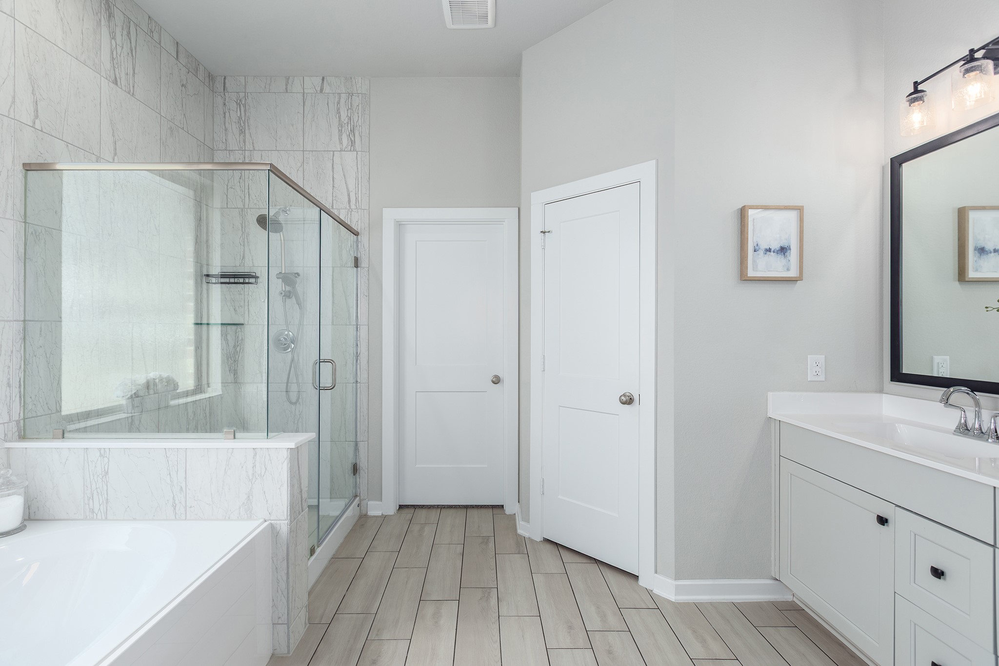 107 Yellow Perch Way Conroe, TX 77318 - Photo 27 of 44 Spacious primary bathroom showcasing dual-sink vanity, soaking tub, glass-enclosed walk-in shower, and tile flooring in a bright, well-designed layout.