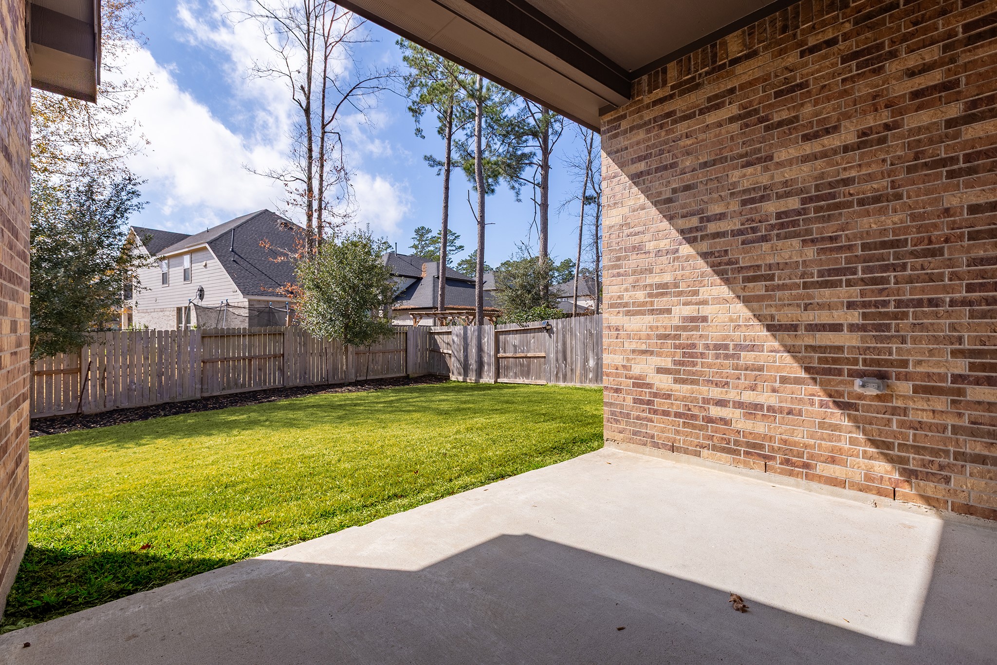 107 Yellow Perch Way Conroe, TX 77318 - Photo 32 of 44 Covered patio overlooking the backyard, offering a comfortable space for outdoor dining, relaxing, or entertaining.