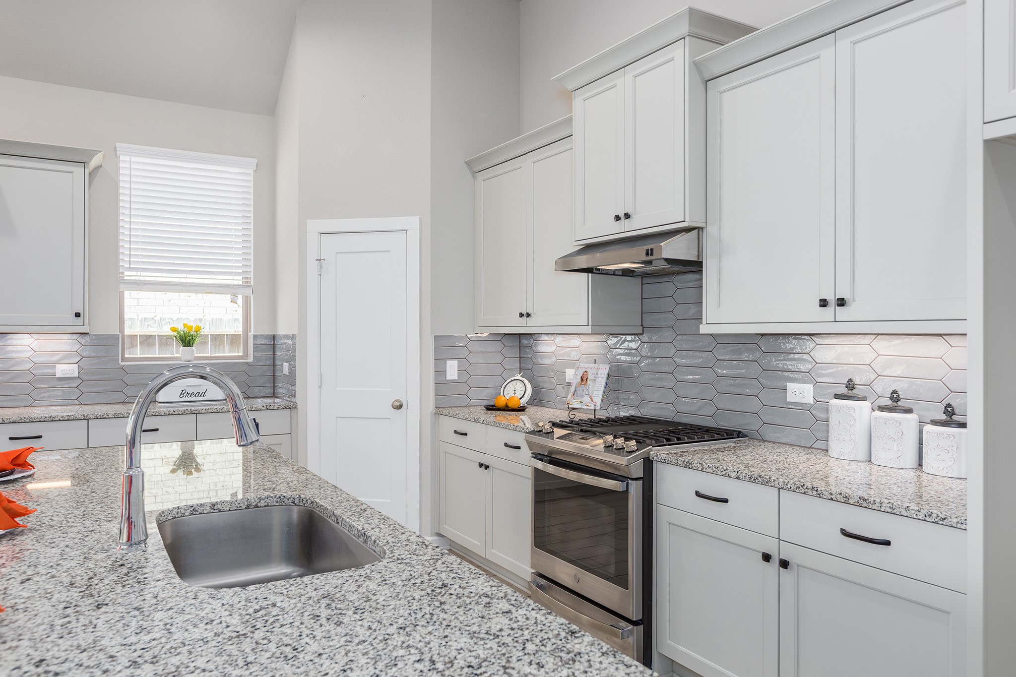 107 Yellow Perch Way Conroe, TX 77318 - Photo 5 of 44 Designed for the home chef, this kitchen offers stainless steel appliances, granite countertops, ample cabinetry, and an eye-catching tile backsplash, all centered around a generous island perfect for prep and entertaining.