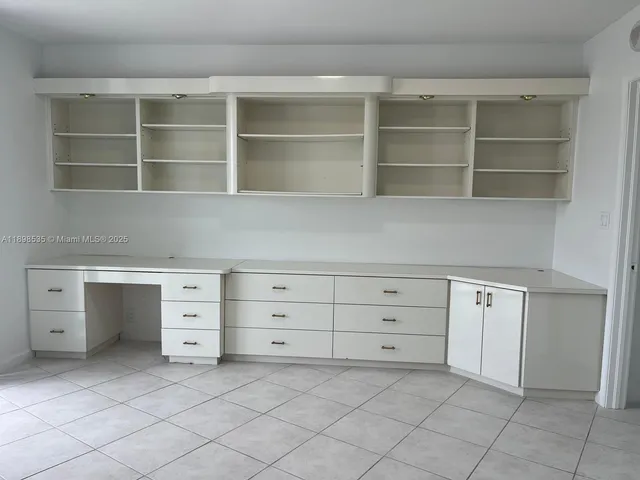a room with white cabinets and a window