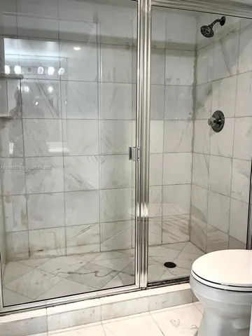 a bathroom with a toilet and a shower