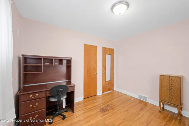 a view of an empty room and wooden floor