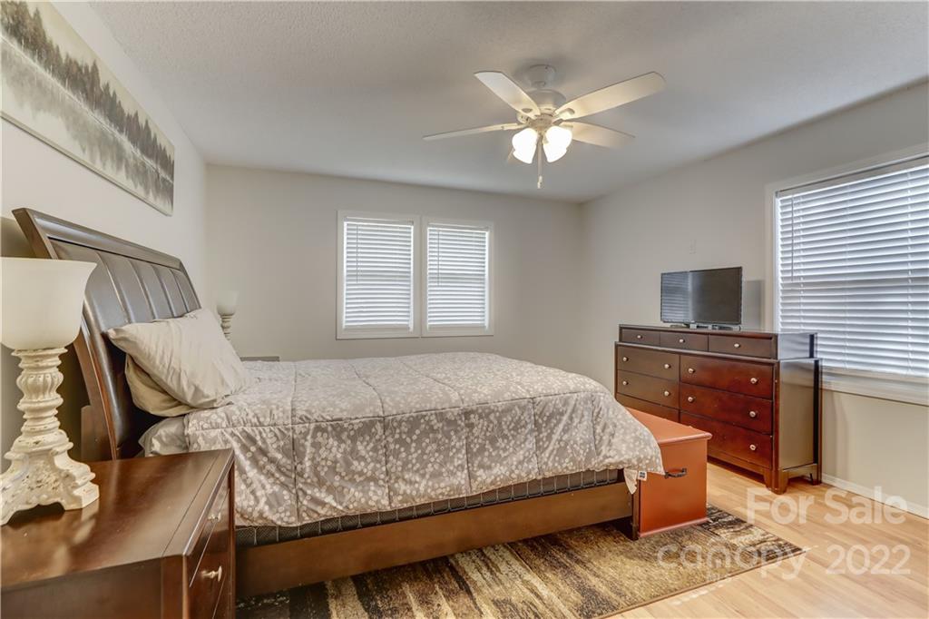 8216 Pine Oak Road Waxhaw, NC 28173 - Photo 18 of 39 a bedroom with a large bed and a chandelier