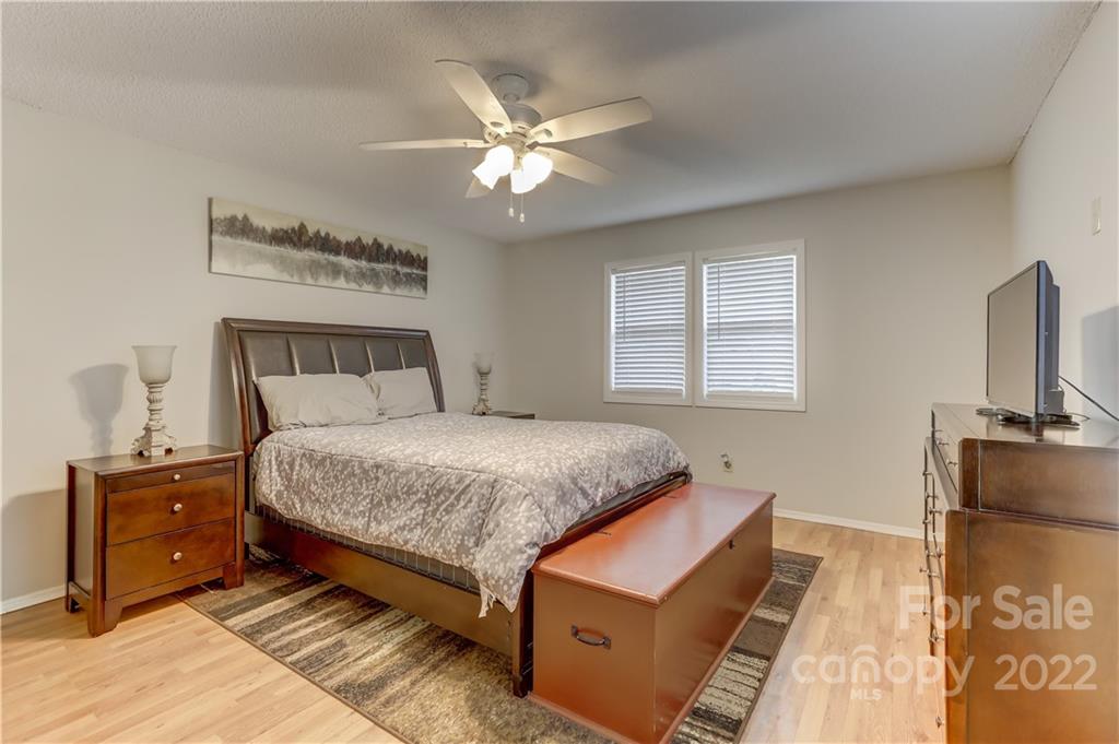 8216 Pine Oak Road Waxhaw, NC 28173 - Photo 19 of 39 a bedroom with a bed and a flat tv screen on a dresser