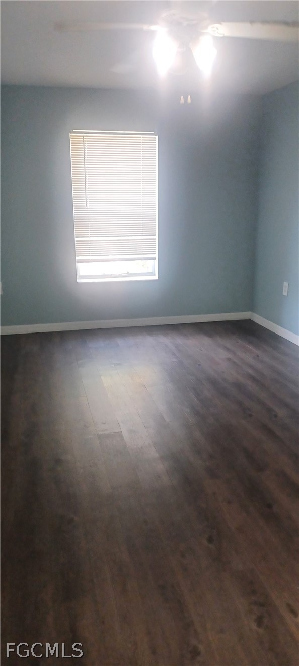 1328 Reflections Way, Unit 1 Immokalee, FL 34142 - Photo 4 of 8 an empty room with wooden floor and windows