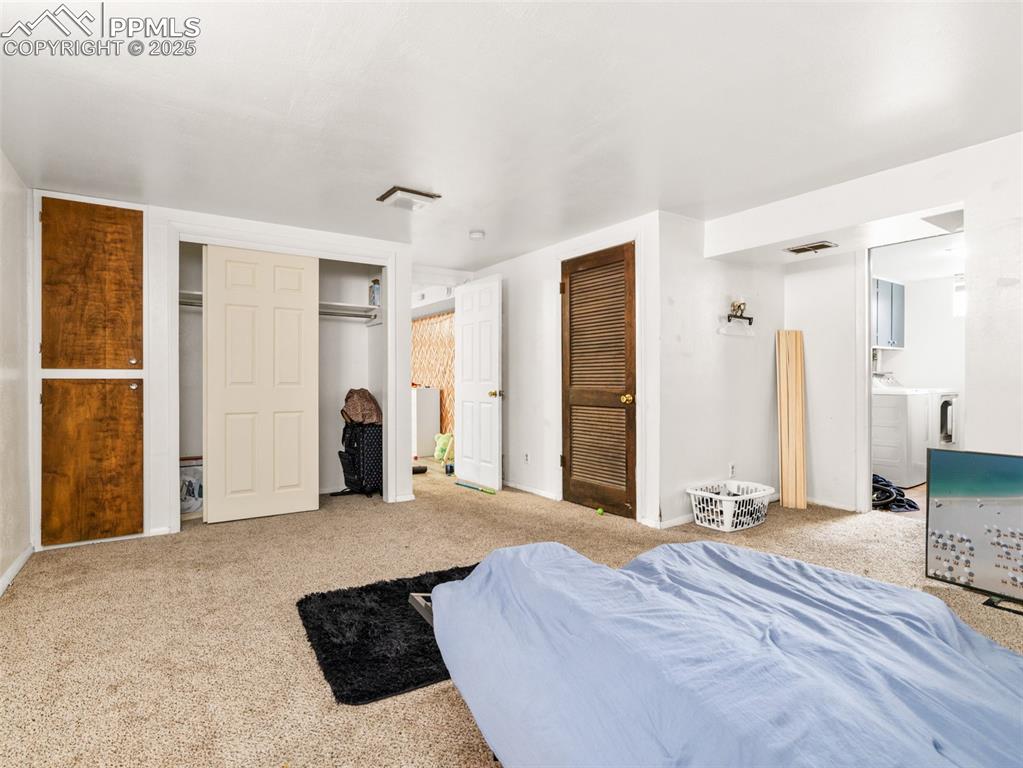 2123 Ridgewood Lane Pueblo, CO 81005 - Photo 15 of 19 a large bedroom with a bed and a large mirror in it