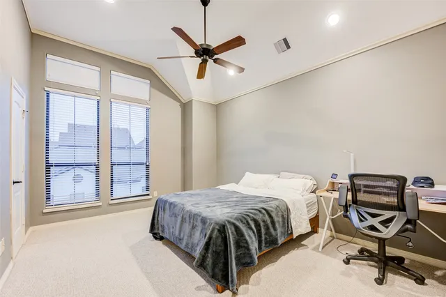 a bedroom with a bed a dresser and a chandelier