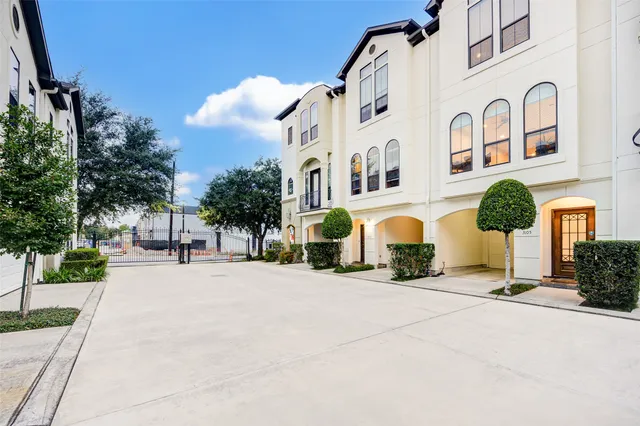 a view of a white house with a yard and plants