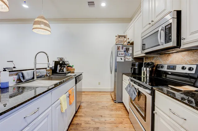 a kitchen with stainless steel appliances granite countertop a stove and a sink