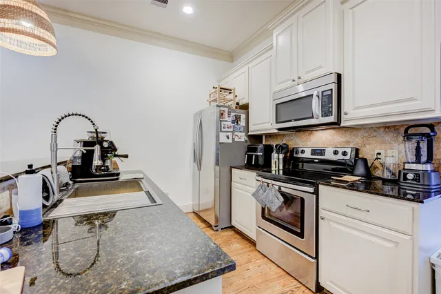 a kitchen with stainless steel appliances granite countertop a sink and a stove