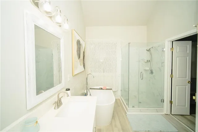a bathroom with a double vanity sink mirror and bathtub