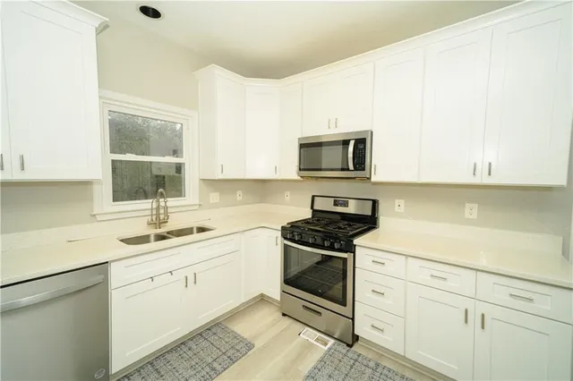 a kitchen with a refrigerator stove and white cabinets