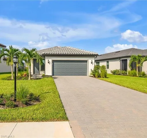 a front view of a house with a garden and yard
