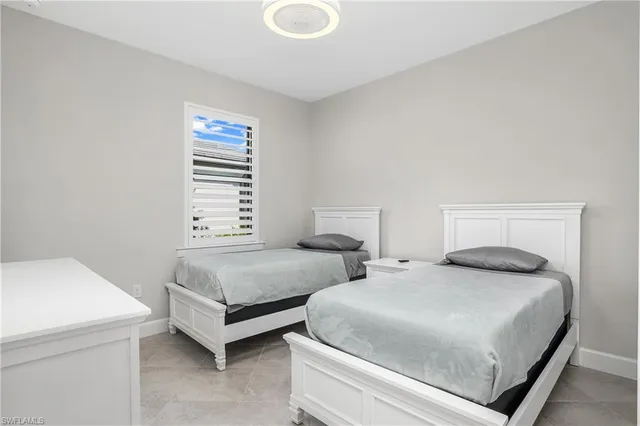 a bedroom with two beds and a window