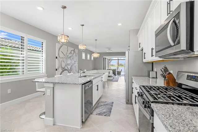 a kitchen with stainless steel appliances granite countertop a sink stove and cabinets