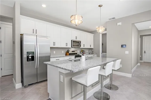 a view of kitchen with sink refrigerator dining table and chairs
