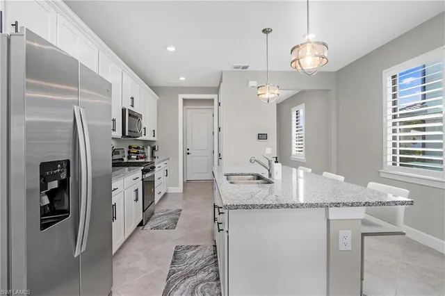 a kitchen with stainless steel appliances granite countertop a sink refrigerator and cabinets