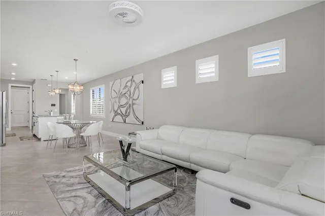 a living room with couches and kitchen view with wooden floor