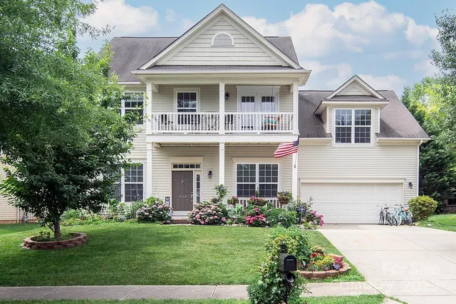 a front view of a house with a yard and trees