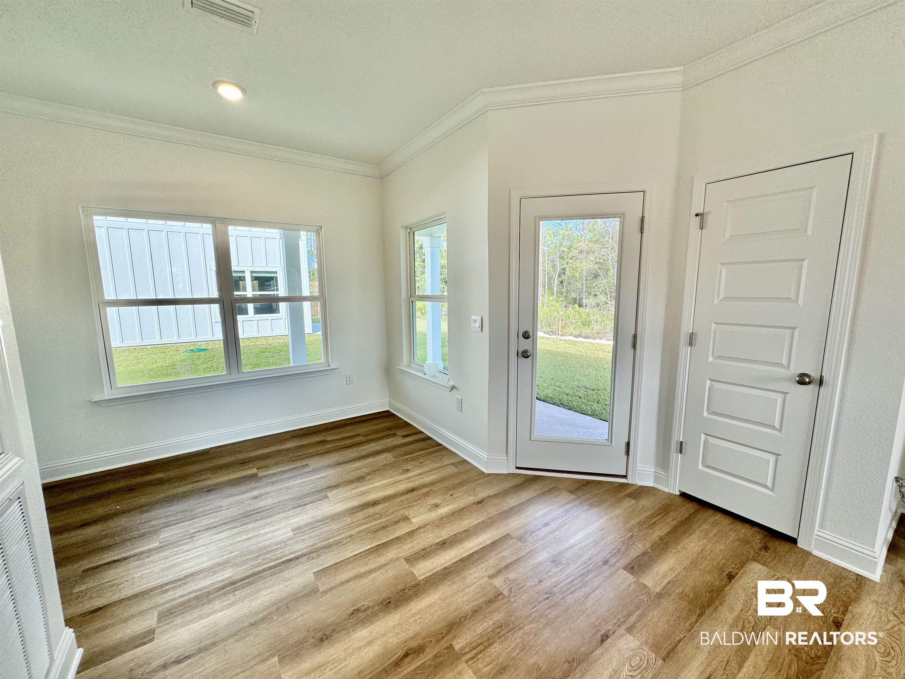 27491 Canal Road Orange Beach, AL 36561 - Photo 13 of 20 Doorway featuring light wood-type flooring and crown molding