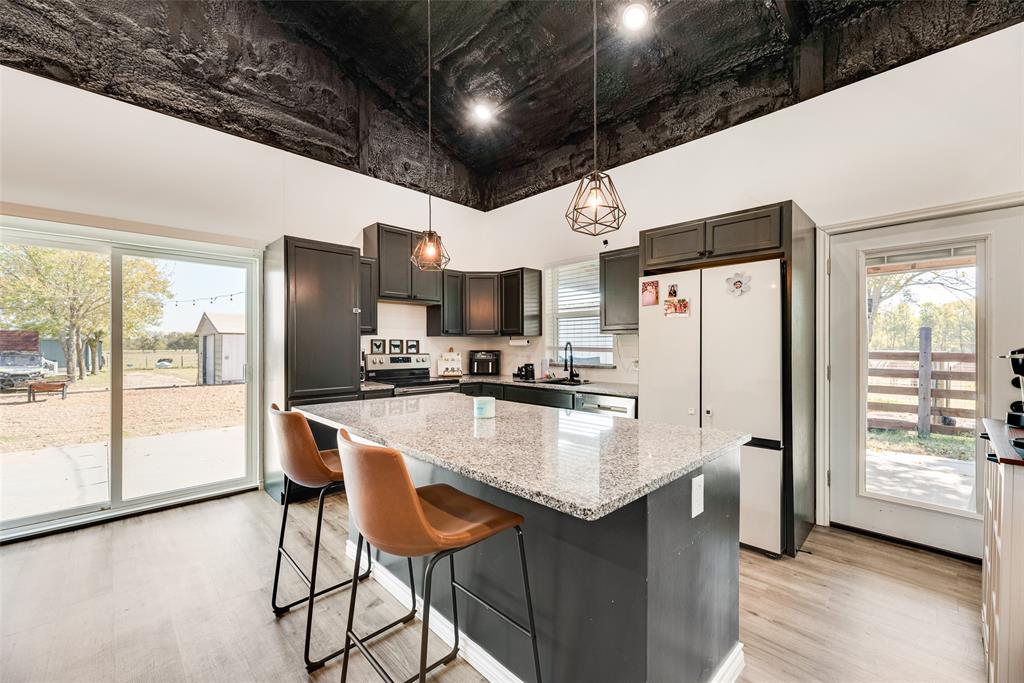 1624 Cemetery Road Royse City, TX 75189 - Photo 20 of 40 a kitchen with stainless steel appliances a dining table chairs refrigerator and sink
