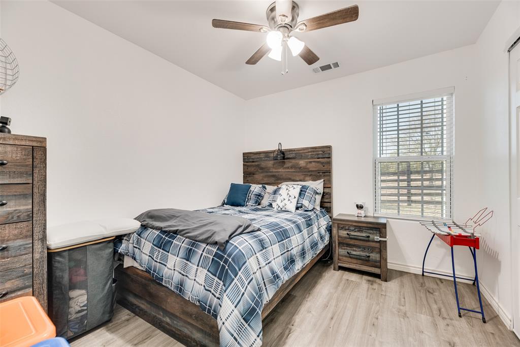 1624 Cemetery Road Royse City, TX 75189 - Photo 23 of 40 a bedroom with a bed and a chandelier